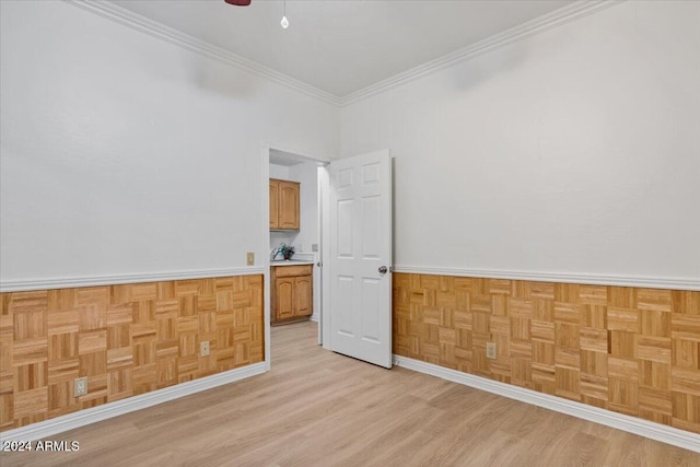 empty room with light wood-type flooring and ornamental molding