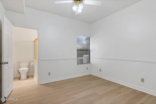 interior space featuring ensuite bath, ceiling fan, and light wood-type flooring