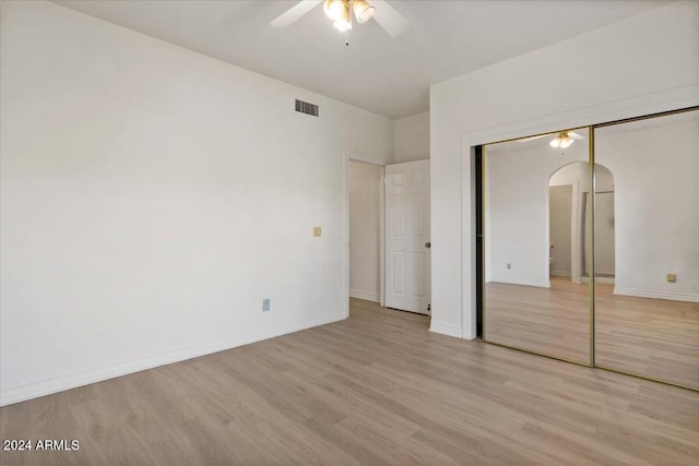 unfurnished bedroom featuring ceiling fan, a closet, and light hardwood / wood-style floors