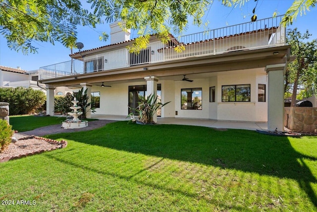 rear view of house with a yard, a patio, and a balcony