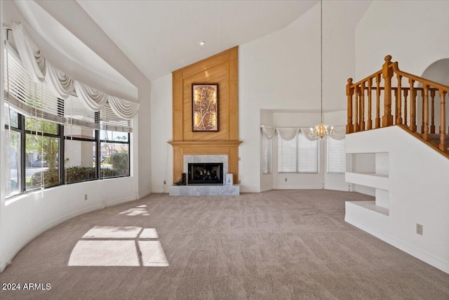 carpeted living room featuring a high end fireplace, a chandelier, and high vaulted ceiling