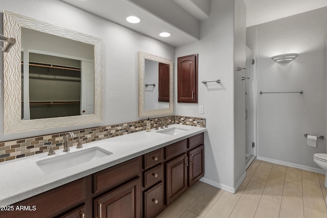 bathroom with vanity, backsplash, and toilet