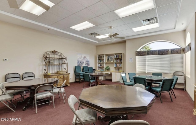 dining room with a paneled ceiling, ceiling fan, and carpet flooring