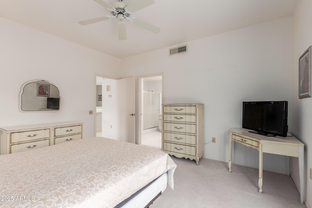 bedroom with connected bathroom, visible vents, ceiling fan, and light carpet