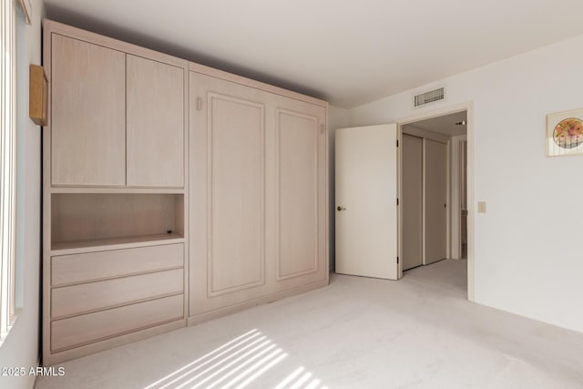 unfurnished bedroom with light colored carpet and visible vents