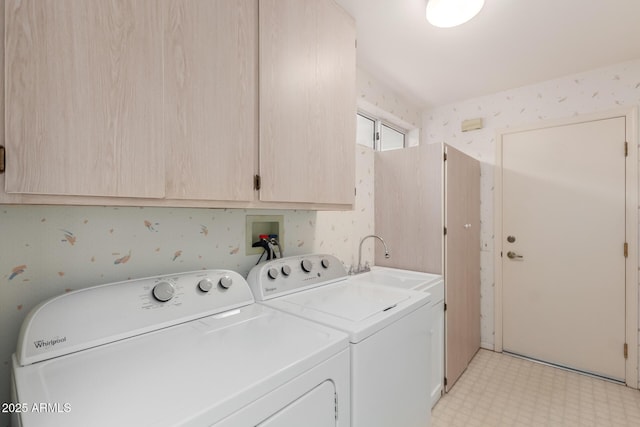 laundry area featuring wallpapered walls, cabinet space, washing machine and clothes dryer, light floors, and a sink