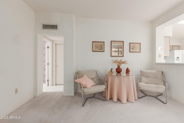 living area featuring carpet floors and visible vents