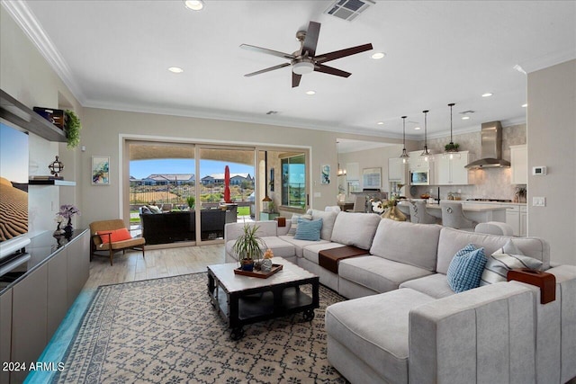 living room featuring crown molding, light hardwood / wood-style floors, and ceiling fan