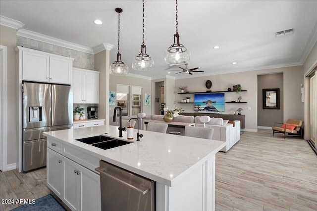 kitchen featuring sink, white cabinets, light hardwood / wood-style flooring, a center island with sink, and stainless steel appliances