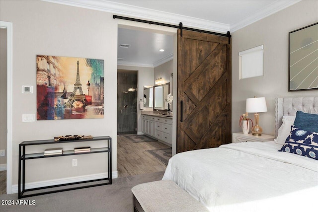 bedroom with a barn door, connected bathroom, crown molding, and dark hardwood / wood-style flooring