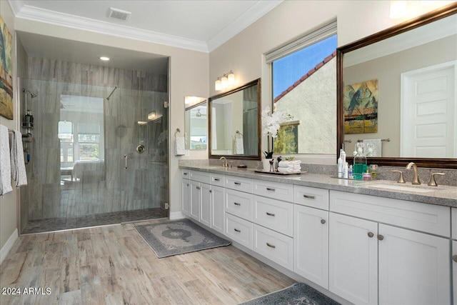 bathroom featuring dual sinks, a shower with door, and large vanity