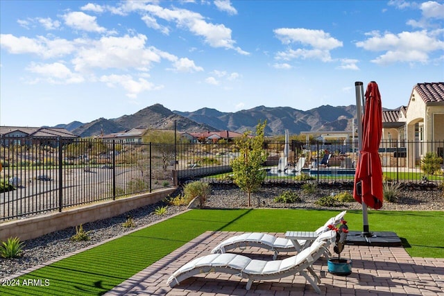 exterior space with a community pool, a patio area, and a mountain view