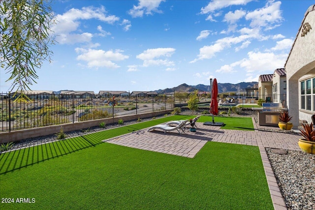 view of yard with an outdoor fire pit, a mountain view, and a patio