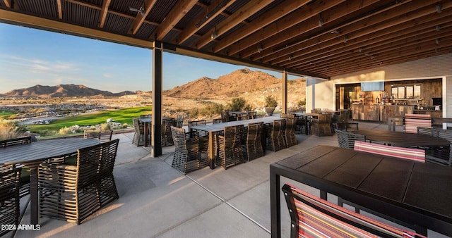 view of terrace with a mountain view, a jacuzzi, and a bar