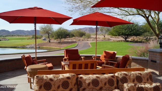 view of patio / terrace with a water and mountain view and an outdoor living space