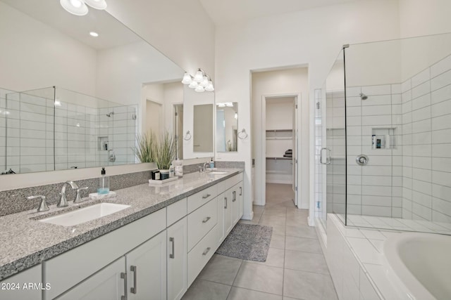 full bath featuring tile patterned flooring, a sink, double vanity, a stall shower, and a walk in closet