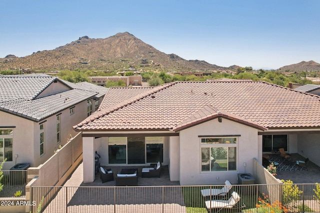 back of property with an outdoor living space, a mountain view, a tiled roof, and stucco siding