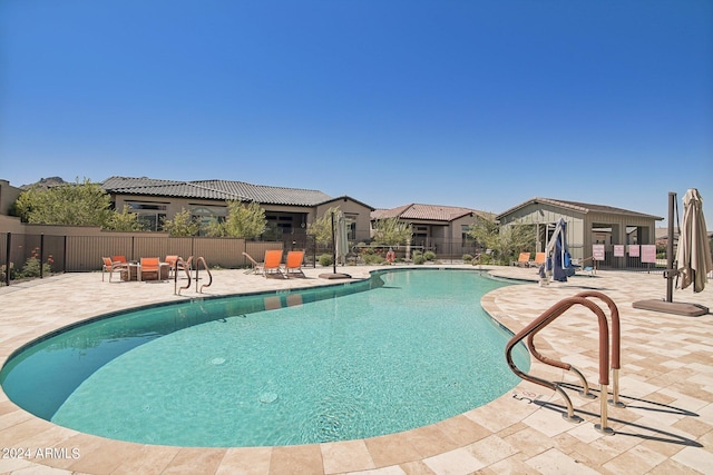 pool featuring fence and a patio