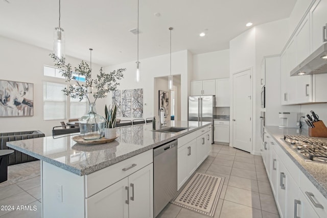 kitchen featuring stainless steel appliances, visible vents, a sink, an island with sink, and wall chimney exhaust hood