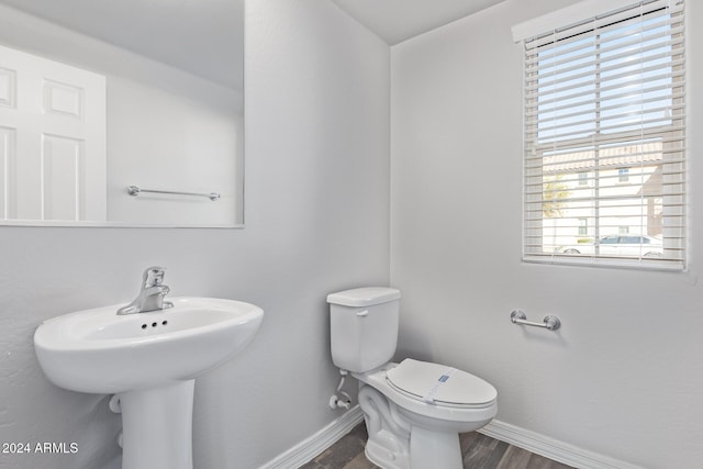 bathroom with hardwood / wood-style floors, a healthy amount of sunlight, and toilet