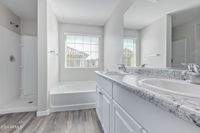 bathroom with hardwood / wood-style floors, vanity, and separate shower and tub