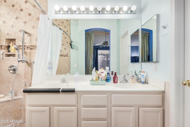 bathroom featuring curtained shower, ceiling fan, and vanity