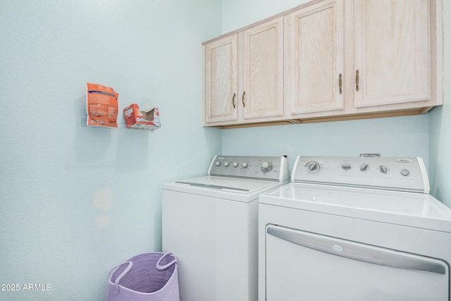 laundry area featuring washing machine and dryer and cabinets