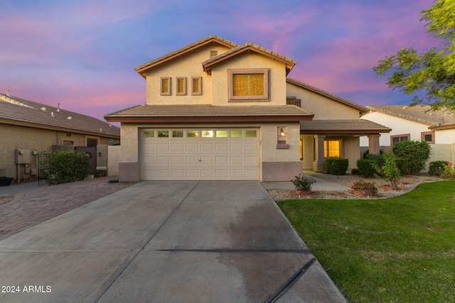 view of front of house with a garage and a yard