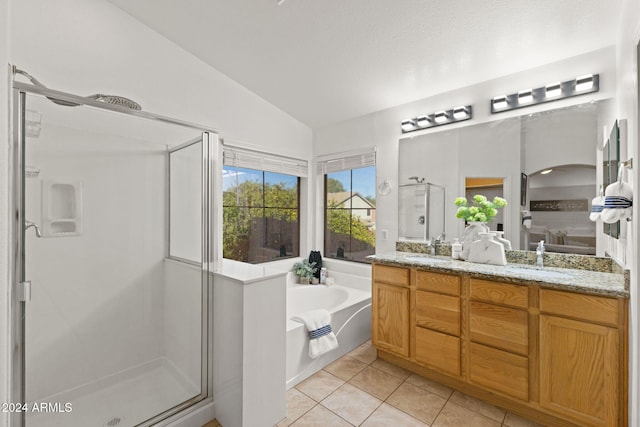 bathroom with tile patterned flooring, vanity, separate shower and tub, and vaulted ceiling