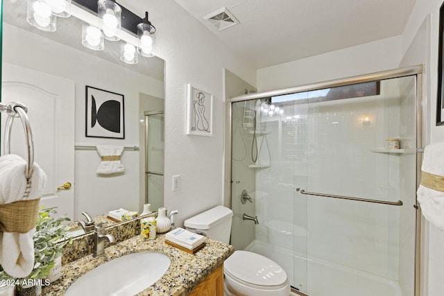 bathroom featuring toilet, vanity, and walk in shower