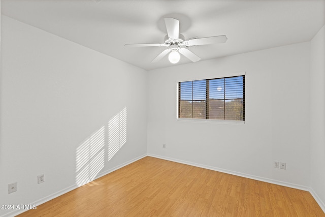 empty room with ceiling fan and light hardwood / wood-style flooring