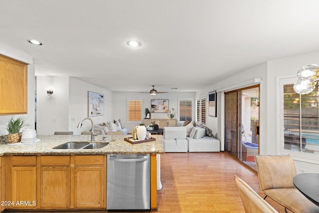 kitchen with ceiling fan, light hardwood / wood-style floors, light stone countertops, and sink