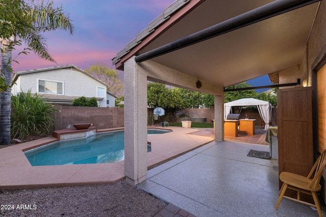 pool at dusk with a patio