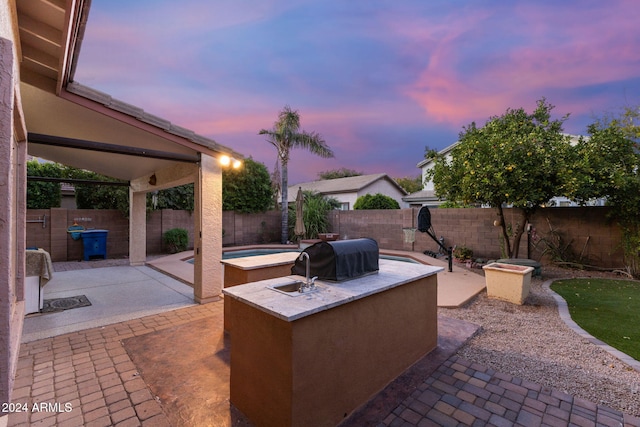 patio terrace at dusk featuring exterior kitchen