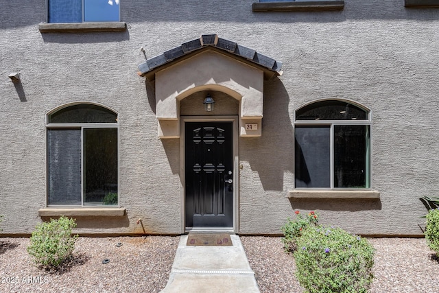 property entrance with stucco siding