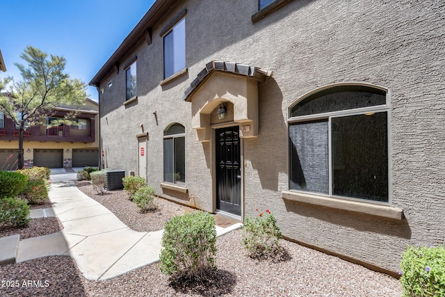 property entrance featuring stucco siding and central AC