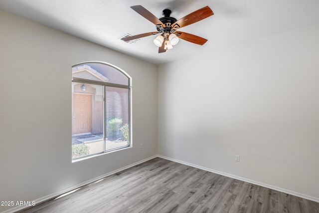 empty room featuring baseboards, ceiling fan, and wood finished floors