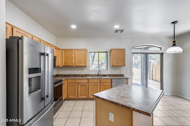 kitchen featuring visible vents, a sink, dark countertops, and stainless steel appliances