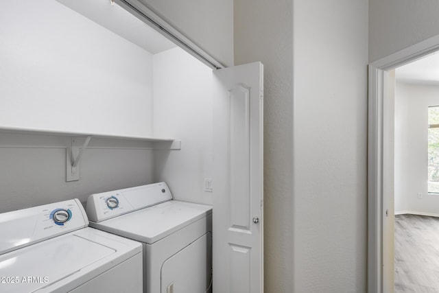 clothes washing area featuring laundry area, washer and clothes dryer, and light wood-style floors