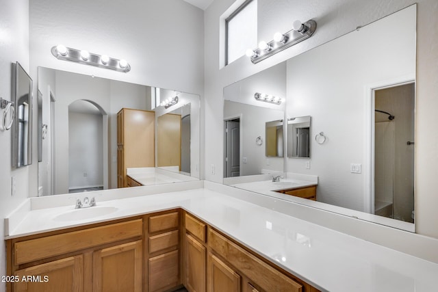 full bathroom featuring double vanity, walk in shower, and a sink