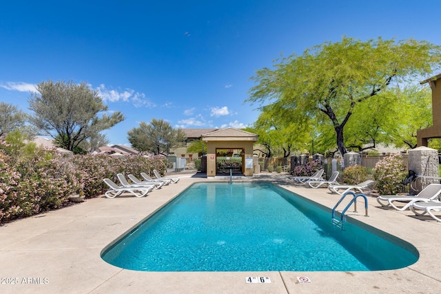 community pool with a patio and fence