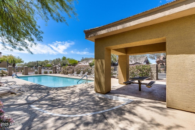 community pool featuring a patio and fence