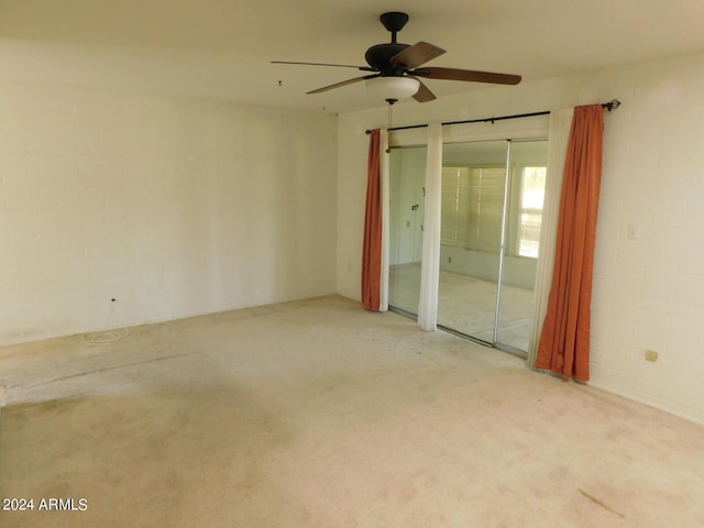 spare room featuring light carpet and ceiling fan