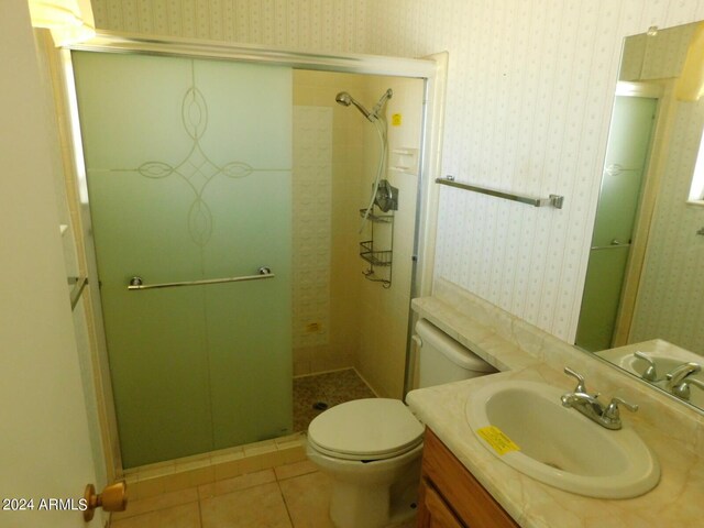 bathroom featuring toilet, vanity, tile patterned floors, and an enclosed shower