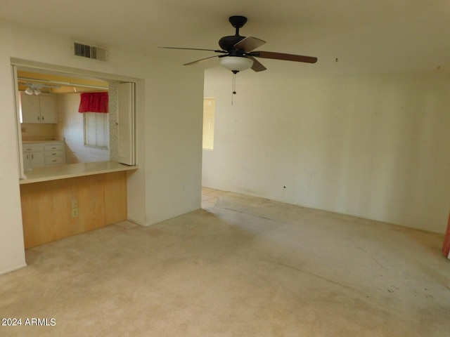 unfurnished living room with light colored carpet and ceiling fan