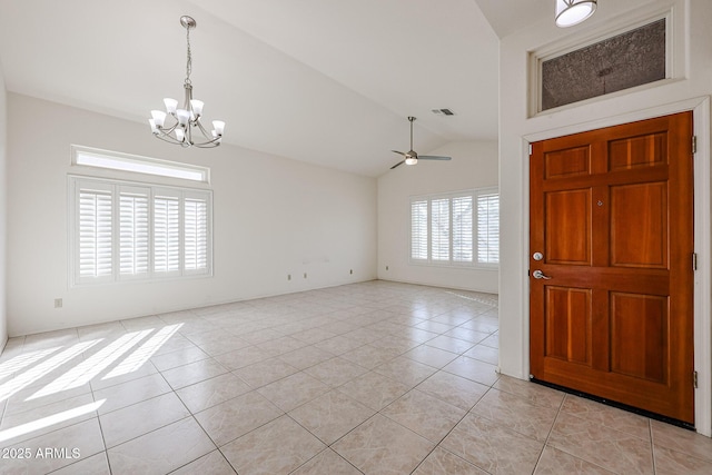 foyer entrance with vaulted ceiling, ceiling fan with notable chandelier, and light tile patterned floors