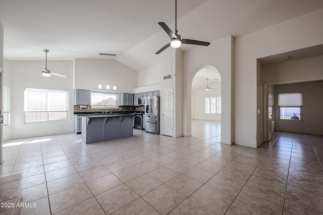 kitchen featuring stainless steel appliances, a center island, a wealth of natural light, and ceiling fan