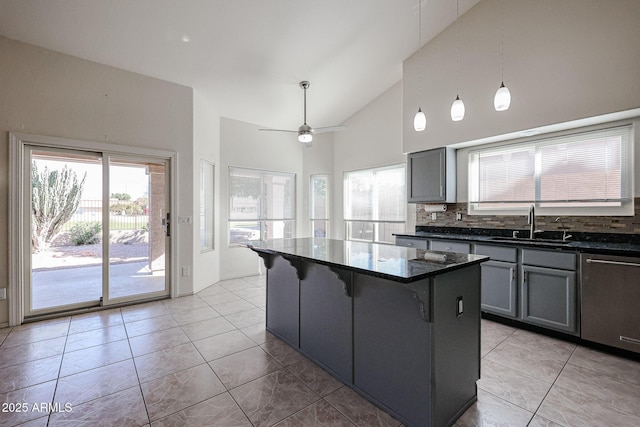 kitchen with gray cabinets, decorative light fixtures, a kitchen breakfast bar, a center island, and stainless steel dishwasher