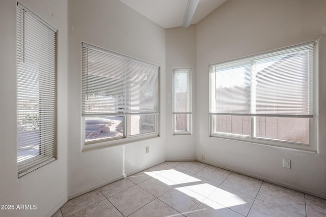 tiled empty room featuring a healthy amount of sunlight