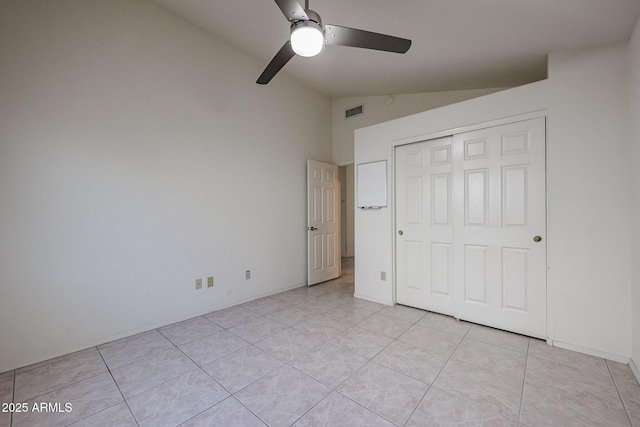 unfurnished bedroom with light tile patterned flooring, ceiling fan, lofted ceiling, and a closet